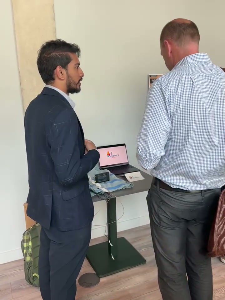 Attendees speaking beside a CE-Track display table at a MedTech Venture Builder event